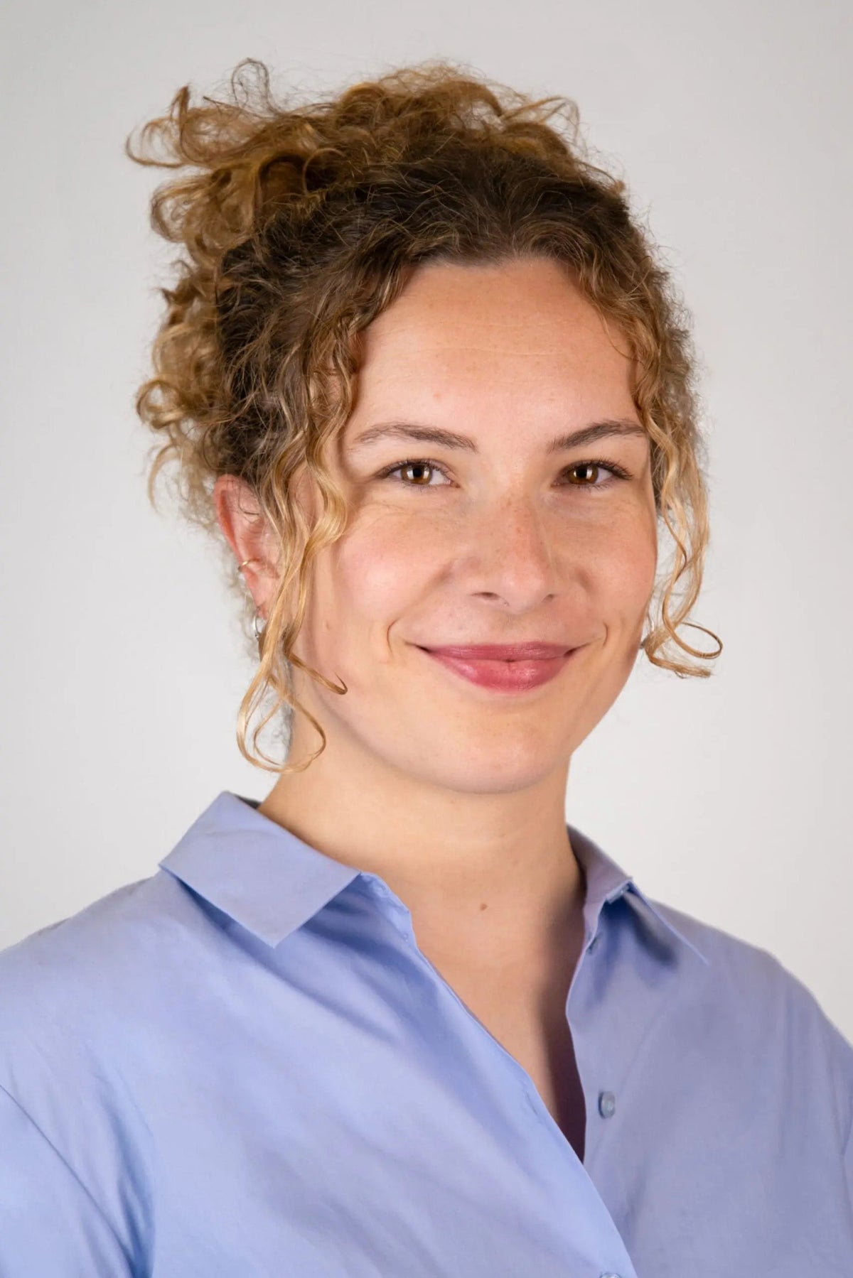 Professional portrait of a woman in a light blue blouse