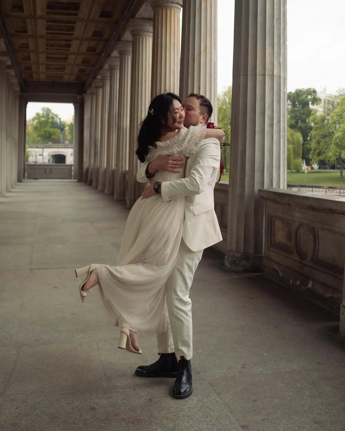Wedding couple embracing in a colonnade