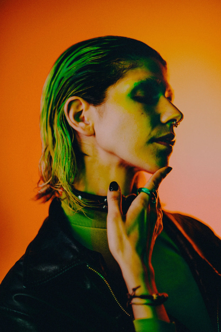 Creative portrait lit with orange and green light