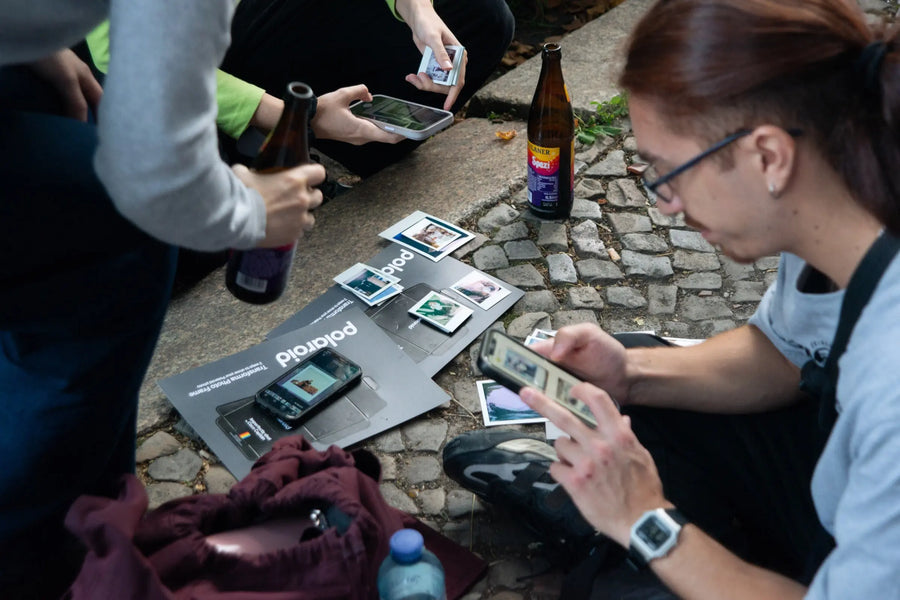 Participants selecting instant prints together around a table