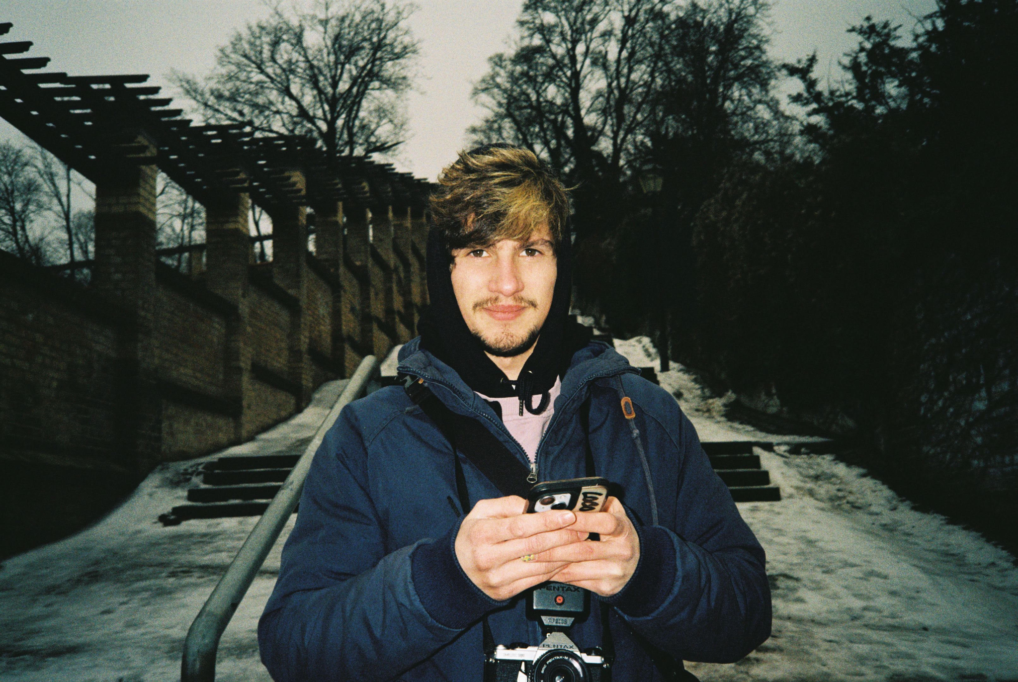 Portrait of Berlin Photo Studio assistant Diogo Pinho holding a Pentax camera