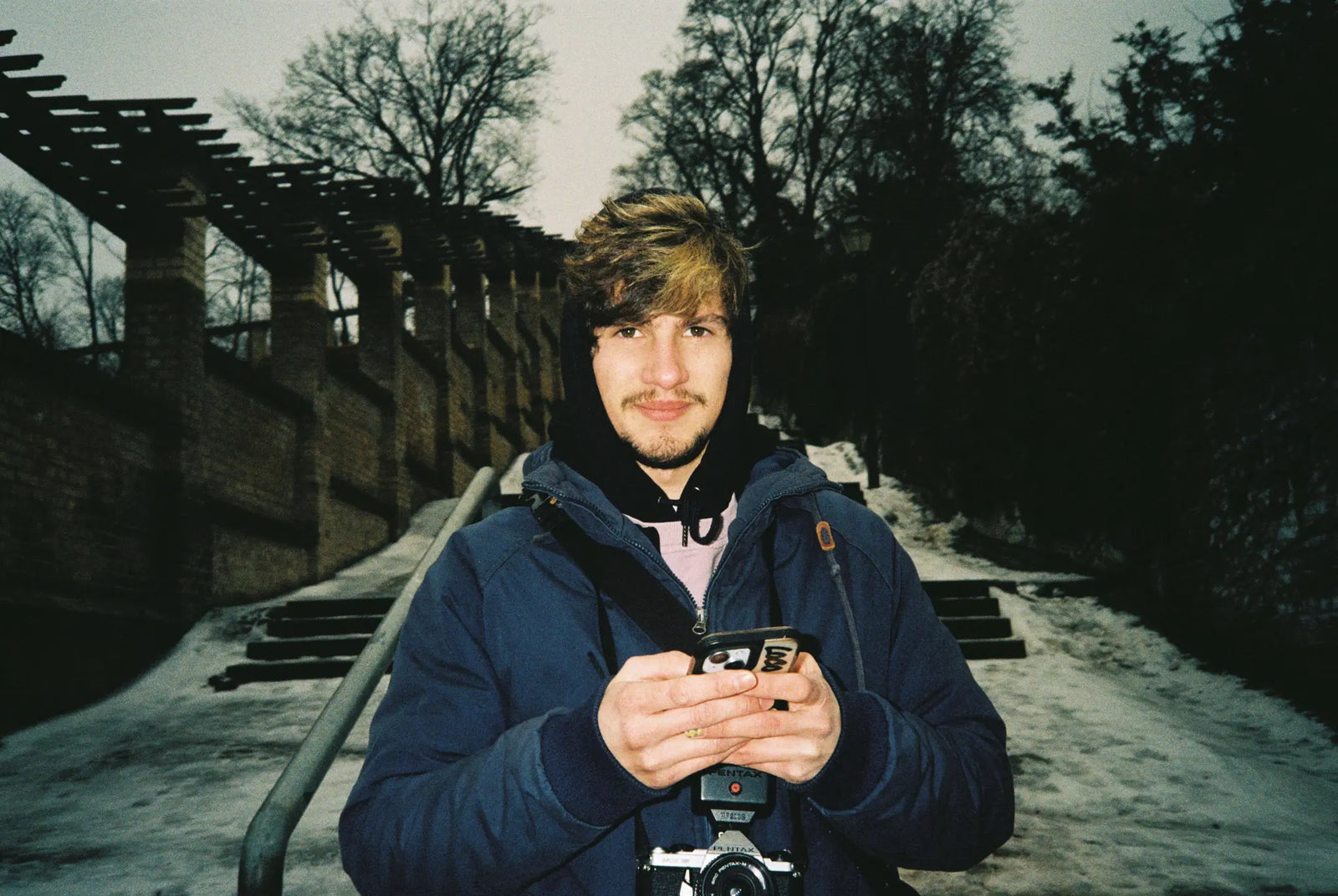 Portrait of Berlin Photo Studio assistant Diogo Pinho holding a Pentax camera