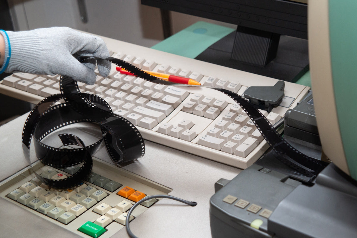 Developed film beside a scanner keyboard and workstation
