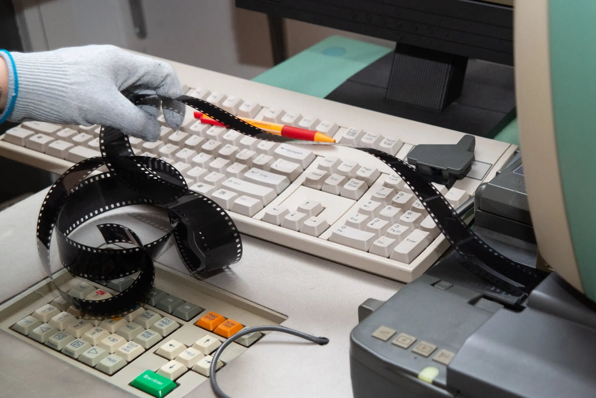 Developed film beside a scanner keyboard and workstation