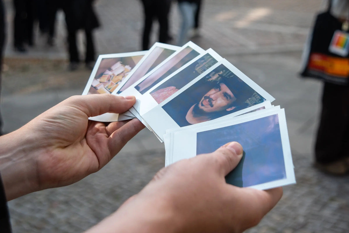 Hands holding a selection of instant prints