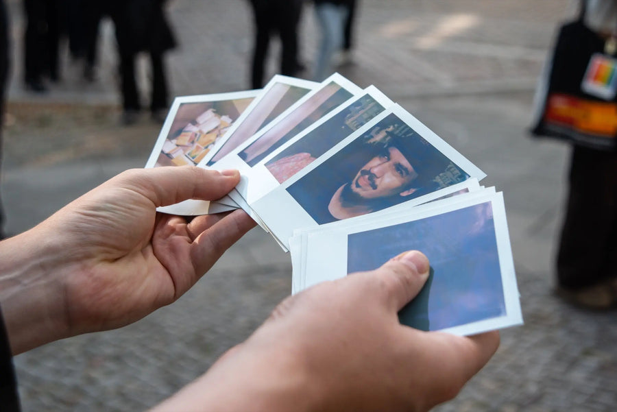 Hands holding a selection of instant prints