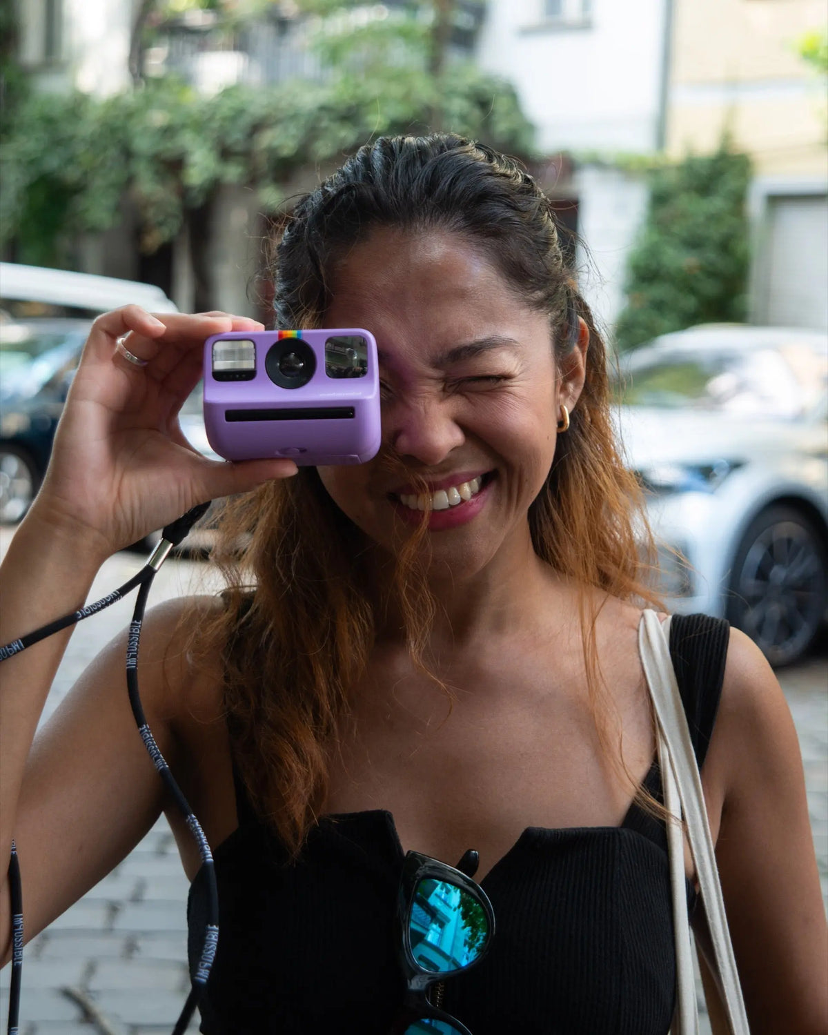 Photographer holding a purple instant camera at eye level