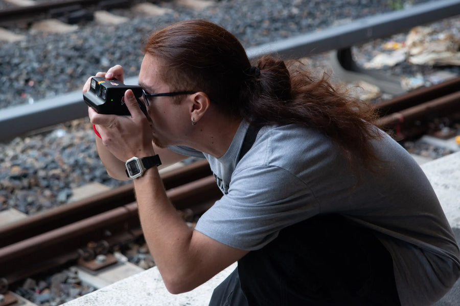 Photographer crouching to compose an outdoor photograph
