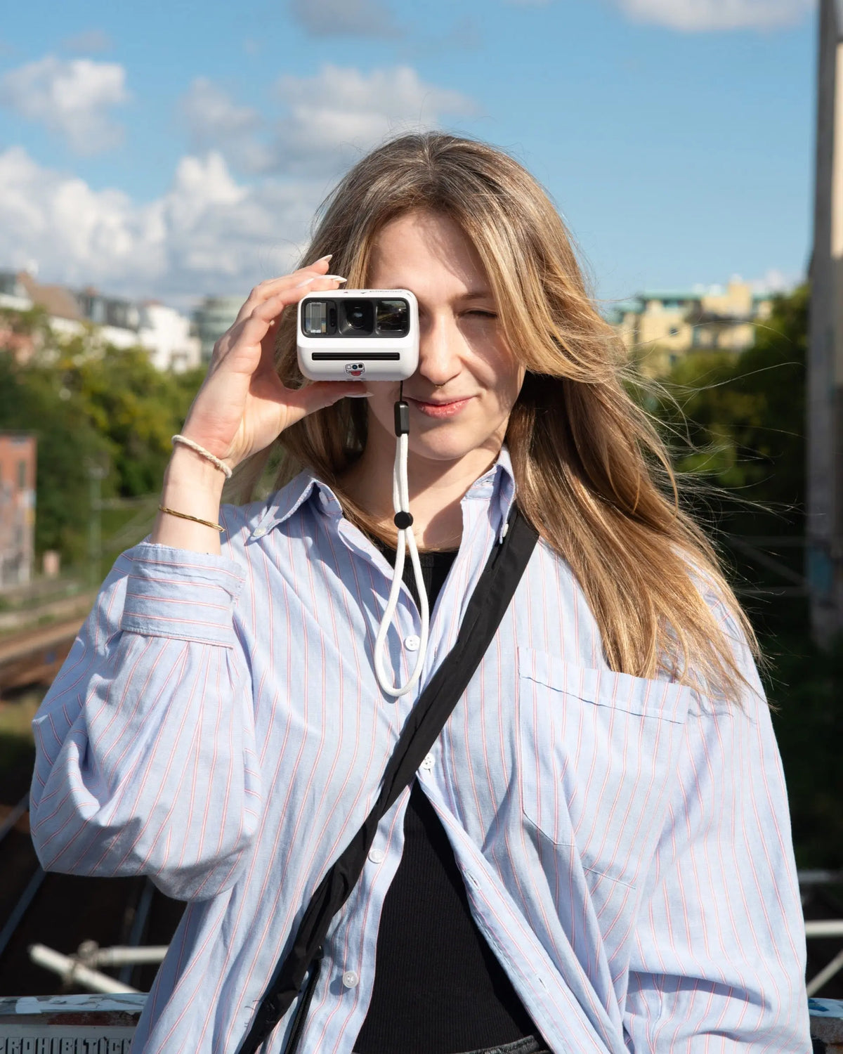 Photographer composing a picture with a white instant camera