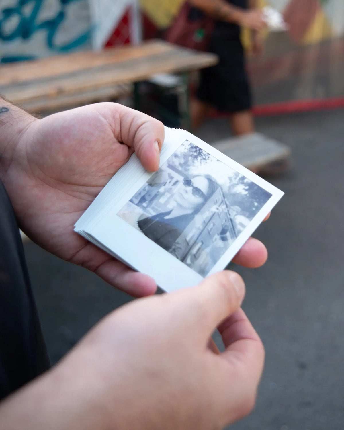 Hands examining a developed instant photograph