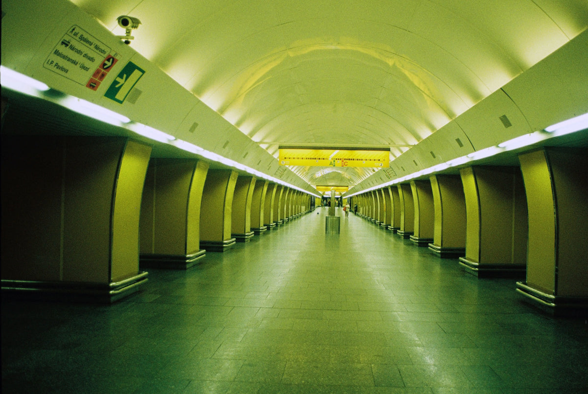 A long green-lit underground passage with columns receding towards the centre.
