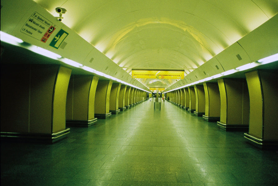 A long green-lit underground passage with columns receding towards the centre.