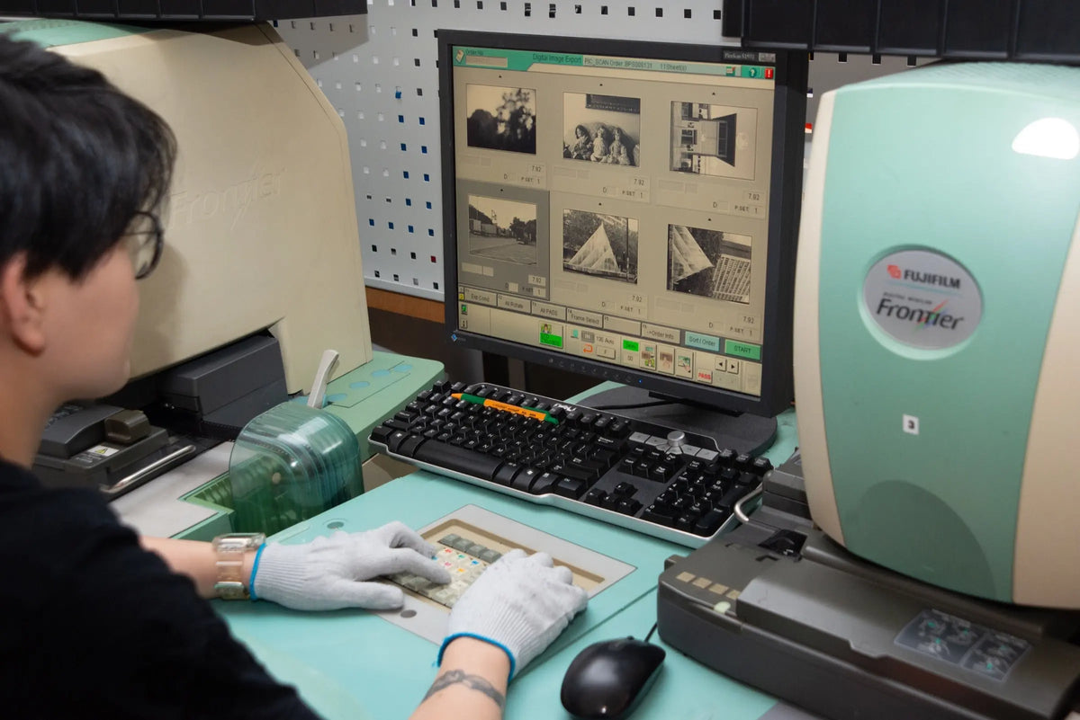 Operator reviewing film images at a Frontier scanning workstation