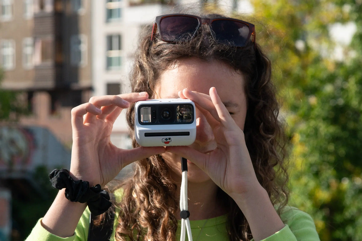 Photographer using an instant camera in bright sunlight