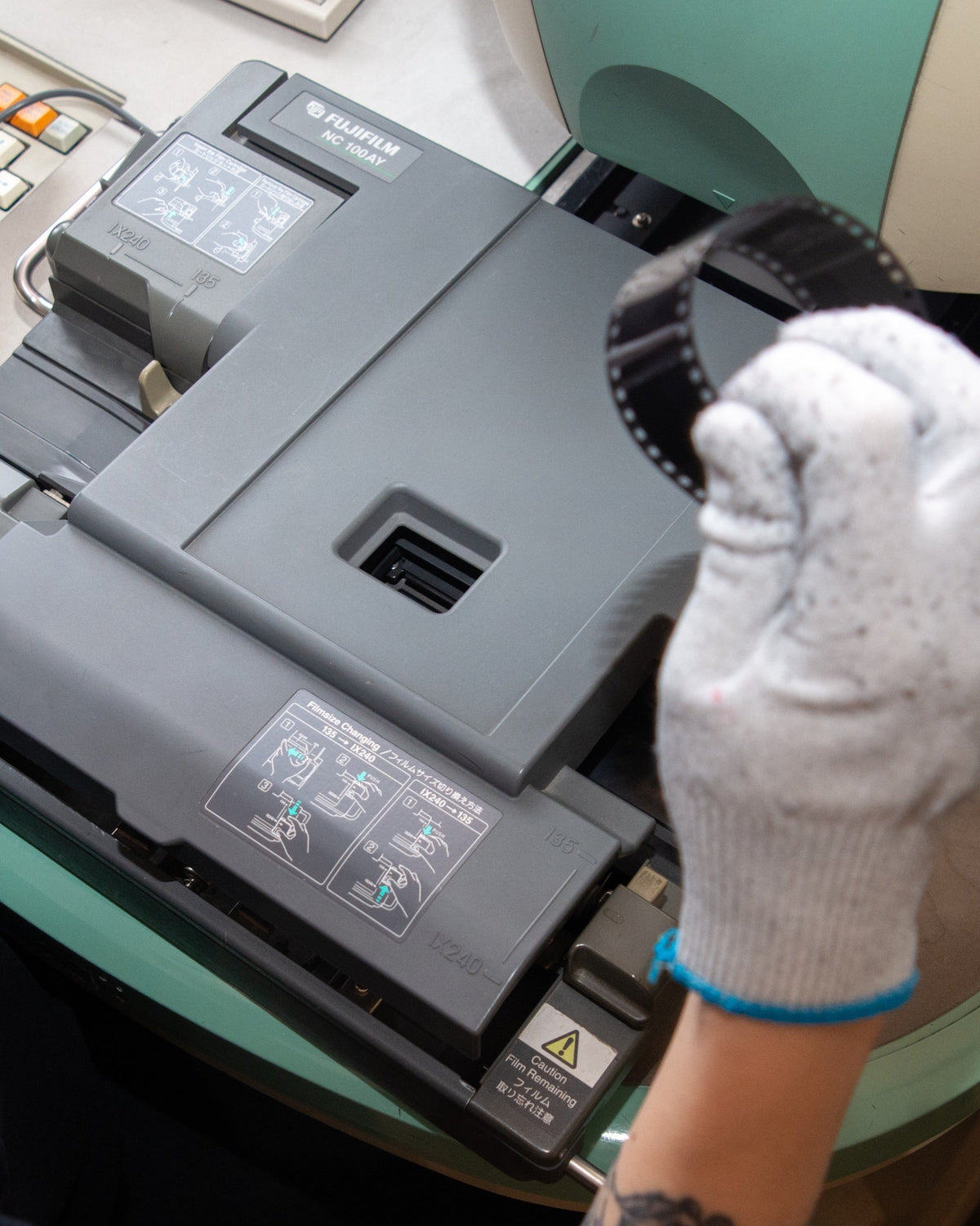 Gloved hand handling the film carrier of a Frontier scanner