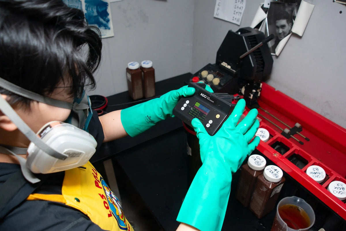 Lab technician adjusting the AGO film processor at Berlin Photo Studio