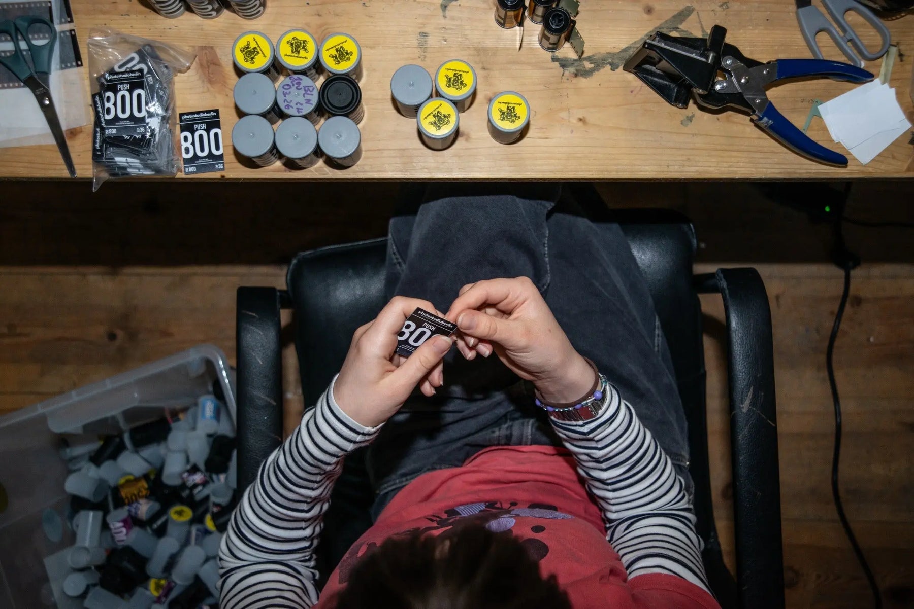 Berlin Photo Studio team member packaging an in-house film roll by hand