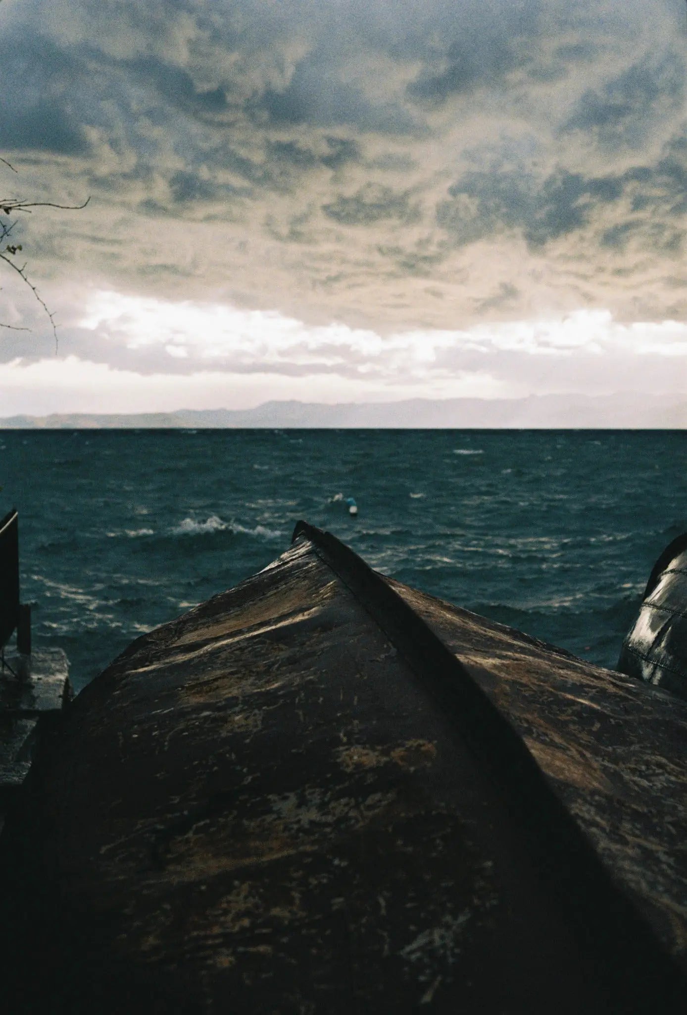 Analogue travel photograph of a dark sea beneath a cloudy sky