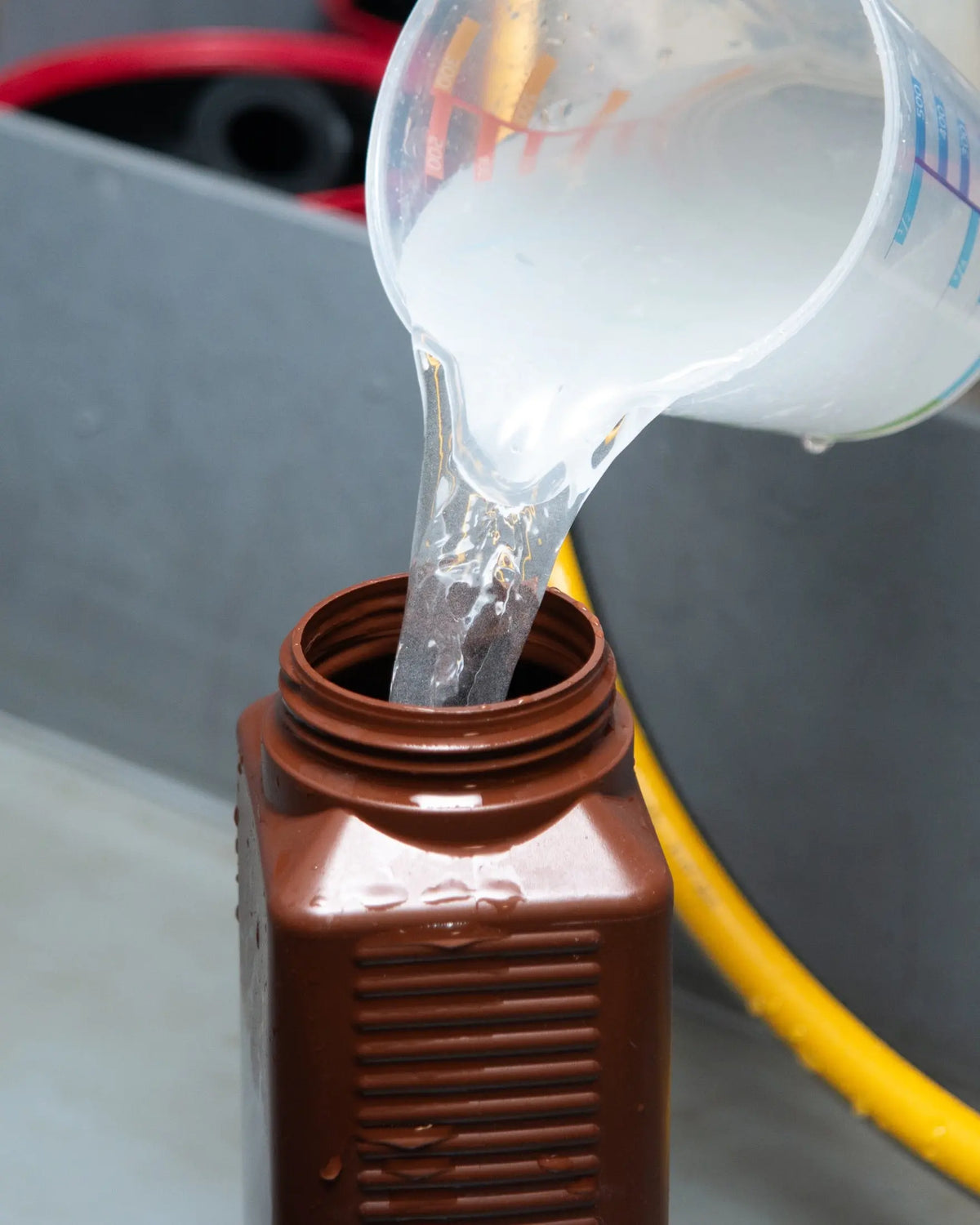 Liquid being poured from a measuring jug into a bottle at Berlin Photo Studio