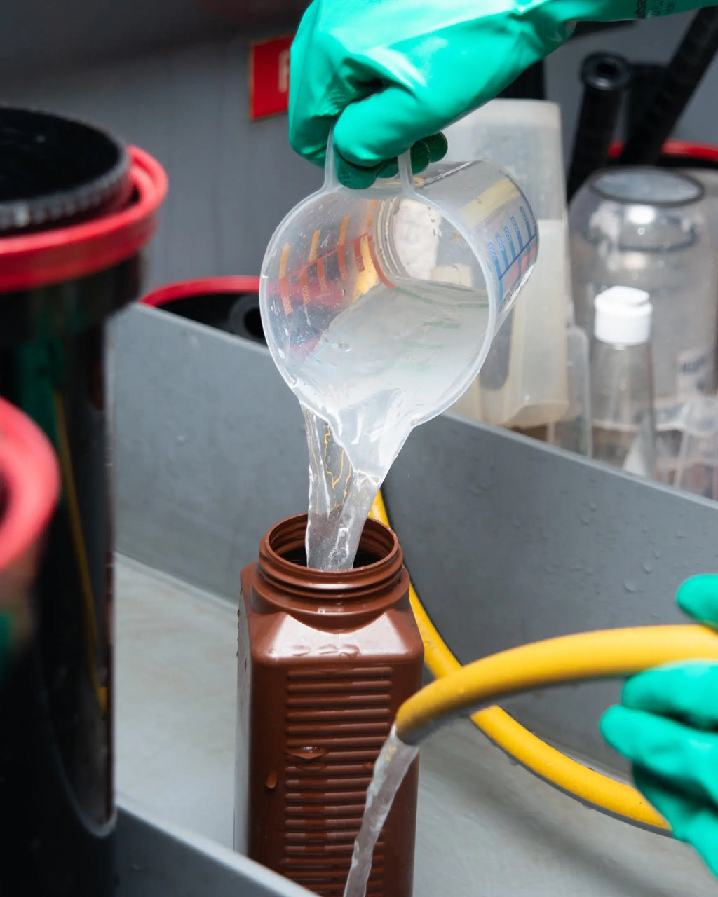 Technician pouring measured liquid into a lab bottle at Berlin Photo Studio