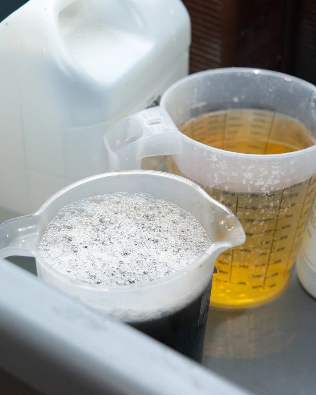 Two graduated jugs of processing solutions at Berlin Photo Studio