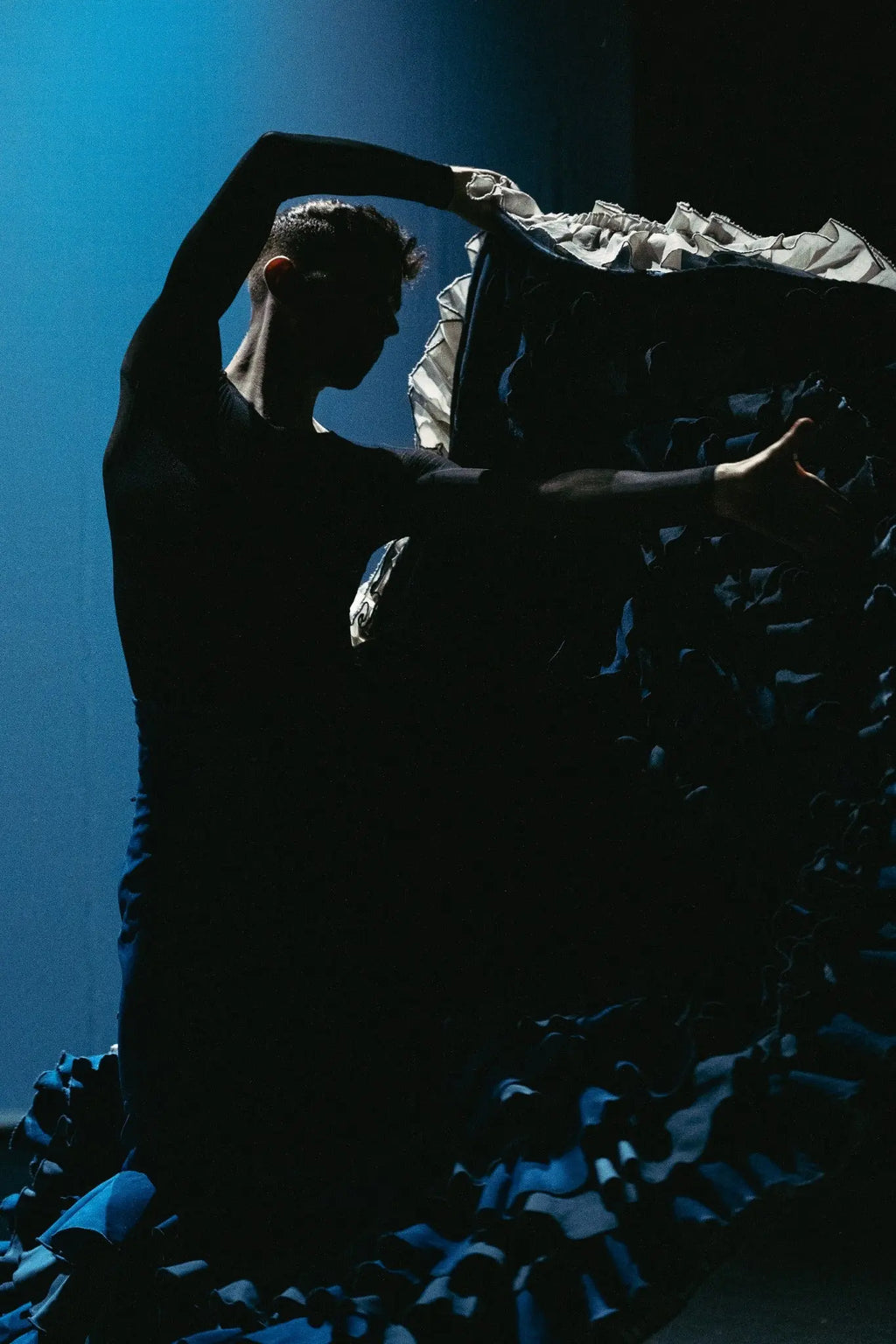 Flamenco performance photographed under dramatic blue stage lighting