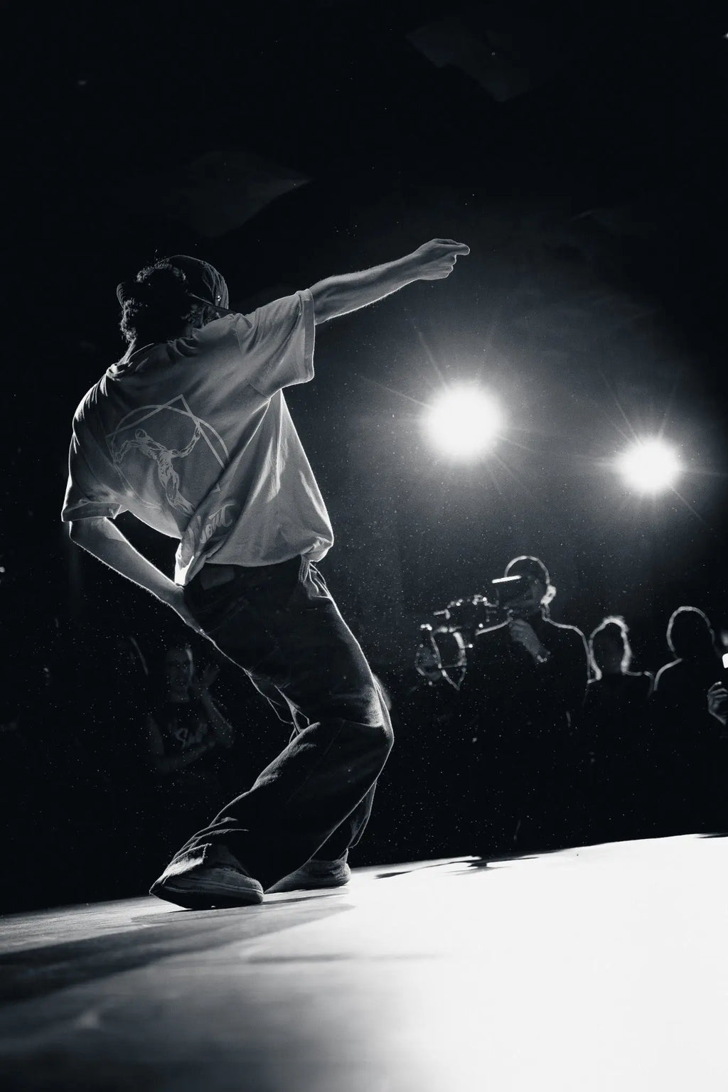 Black and white stage performance photograph of a dancer under spotlights in Berlin